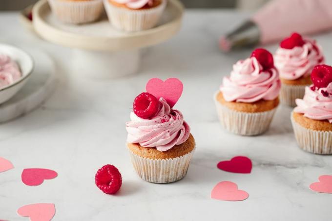 φρεσκοφτιαγμένα cupcakes βατόμουρο στον πάγκο της κουζίνας νόστιμα ροζ cupcakes με γαρνιτούρα από βατόμουρο και χάρτινη καρδιά