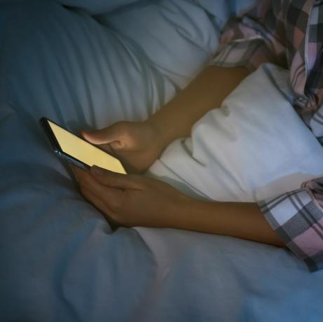 γυναίκα που χρησιμοποιεί smartphone στο κρεβάτι τη νύχτα, νομοφοβία κινηματογραφήσεων σε πρώτο πλάνο και πρόβλημα διαταραχής ύπνου