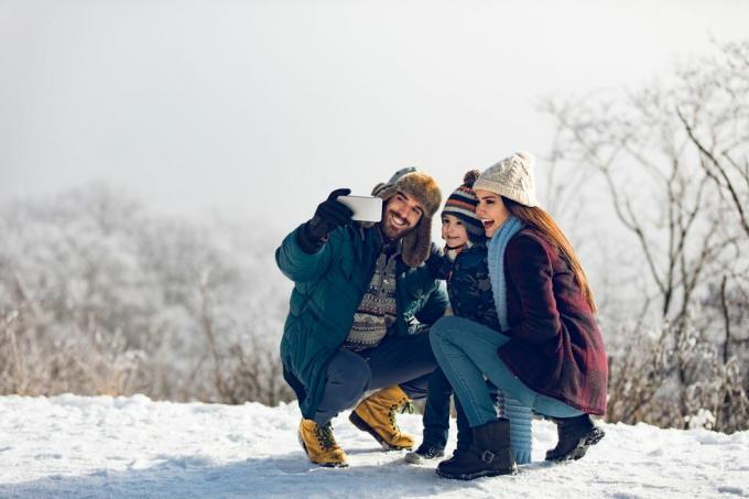 οικογένεια που βγάζει selfie τη χειμωνιάτικη μέρα στο χιονισμένο δάσος