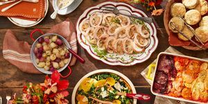 ένα σετ τραπέζι με πιάτα φαγητού που περιλαμβάνει ρουλέτα γαλοπούλας, χειμωνιάτικη σαλάτα, μπισκότα, γκρατέν λαχανικών ρίζας και γλυκόξινα κρεμμύδια